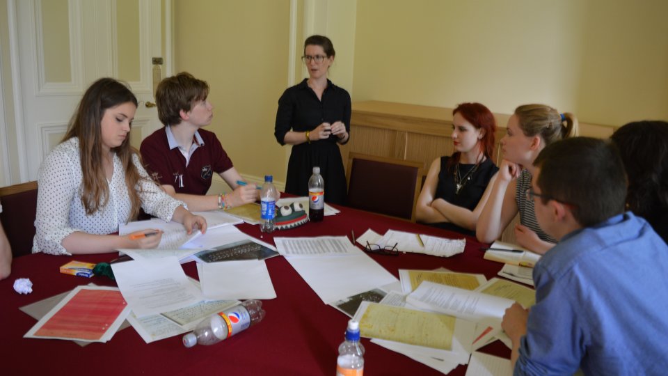 A-level students using facsimiles of archival documents during an interpretation activity, as part of a residential, and discussing them with Dr Alisa Miller (guest speaker at the event).