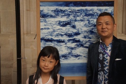 Ceramic artist Gan Daofu with his daughter in front of his painting
